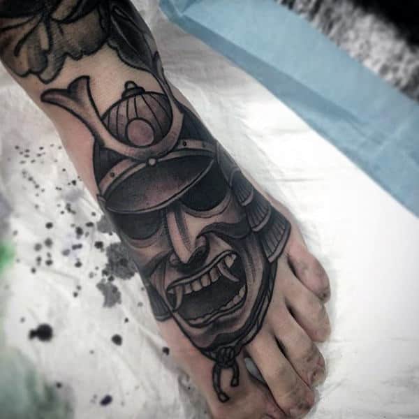 Man With Black Shaded Samurai Mask Foot Tattoo