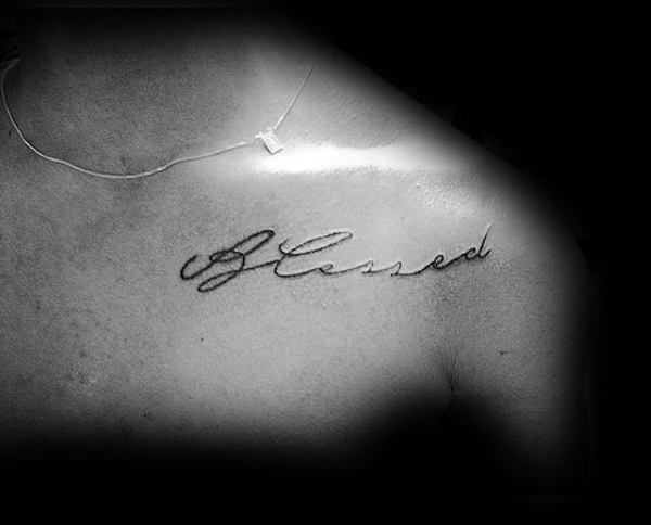 Man With Blessed Handwritten Cursive Tattoo On Upper Chest