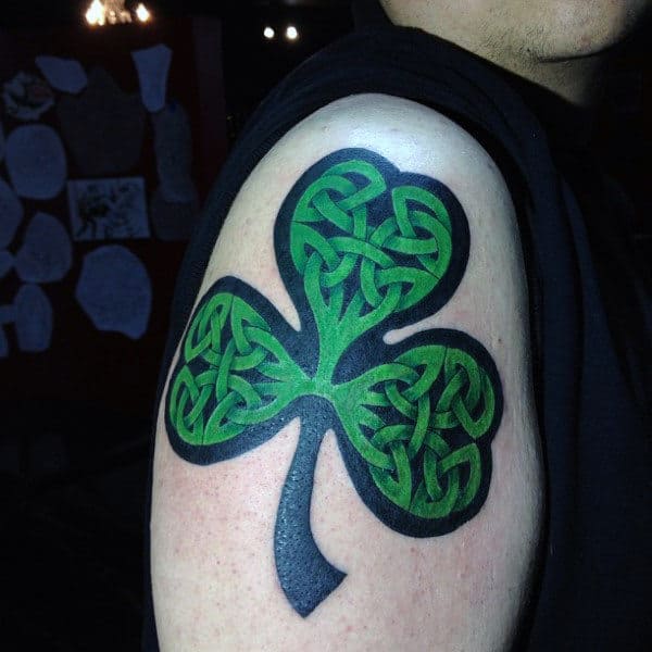 Man With Bold Green And Black Shamrock Upper Arm Tattoo