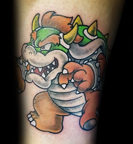 Bold Bowser tattoo on a man's leg featuring vibrant colors, strong outlines, and a fierce pose, capturing his iconic look from the Mario series.