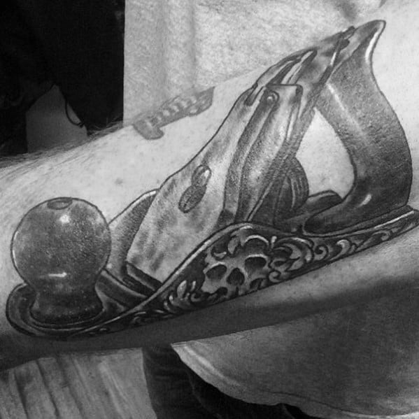 Realistic black and gray tattoo of a vintage hand plane with intricate details, symbolizing craftsmanship, woodworking, and dedication to the trade.