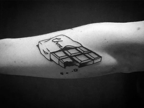 This minimalist black and gray tattoo features a bitten chocolate bar with its wrapper partially peeled back, giving it a simple yet bold look.