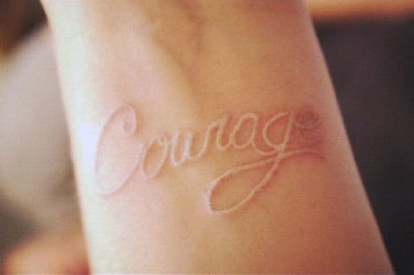 Man With Courage White Ink Lettering Tattoo On Wrist