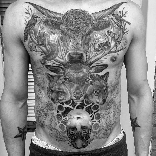 Full black and grey chest-to-stomach tattoo featuring a large bull with antlers, surrounded by forest animals and intricate nature details.