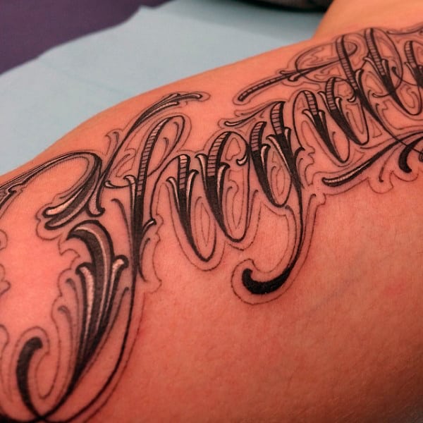 Man With Dark Lettering Tattoo On Shoulder