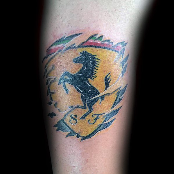 Torn-skin Ferrari shield tattoo showing a black prancing horse, symbolizing inner passion for speed and racing, inked on man's arm.