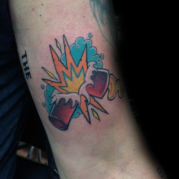 Tattoo of an exploding firecracker with bold orange and blue bursts, surrounded by smoke and sparks, creating a dynamic and energetic design.