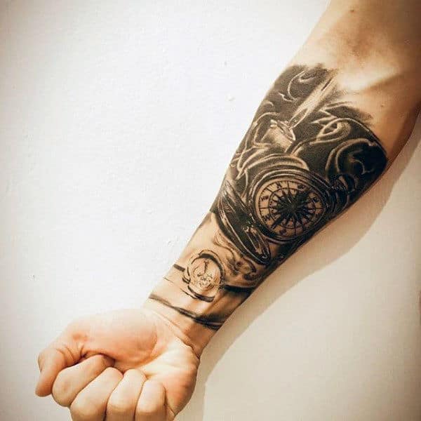 Man With Forearm Sleeve Tattoo Of Compass And Candle Flame