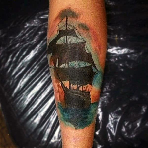 Man With Forearm Tattoo Silhouetted Ship At Sunset Traditional Style