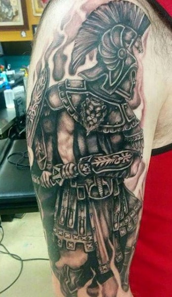 Arm tattoo of a detailed Roman soldier in armor and helmet holding a shield and weapon resembling a powerful gladiator ready for battle