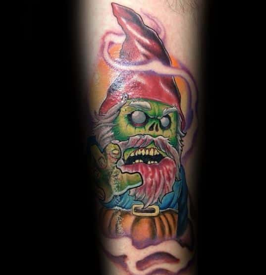 Tattoo of a zombie gnome with glowing green skin, a tattered red hat, and sharp teeth, surrounded by eerie purple mist and a sinister expression.