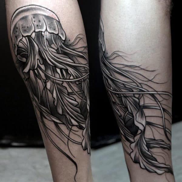 Man With Grey Jelly Fish Tattoo On Lower Legs