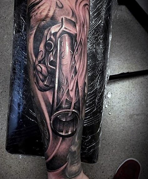 Man With Gun Tattoo Of Barrel On Forearm