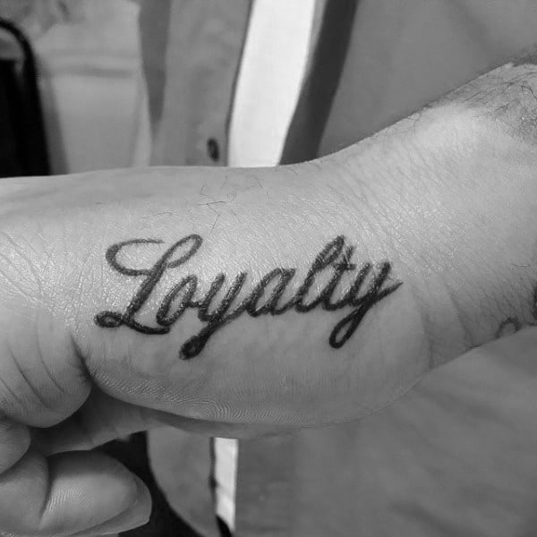 Man With Hand Tattoo Of Loyalty In Cursive Lettering