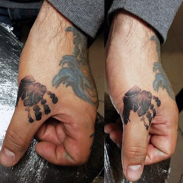 Man With Handprint Tattoo On Thumbs