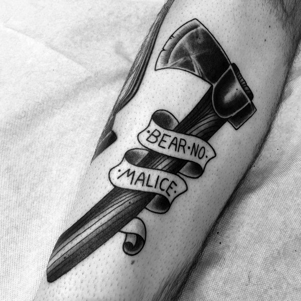 Black and grey hatchet tattoo with a wood-textured handle, a shaded blade, and a flowing banner wrapped around it displaying "BEAR NO MALICE."