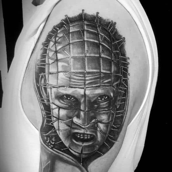 Black and grey tattoo of Pinhead from *Hellraiser*, featuring intricate details of the pins and intense shading for a terrifying horror look.