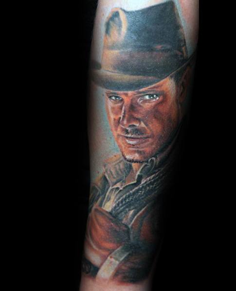 Realistic full-color tattoo of Indiana Jones, capturing his intense gaze, iconic fedora, and adventurous outfit with lifelike shading and detail.
