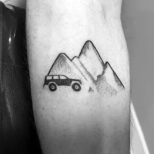 Minimalist black ink tattoo of a Jeep driving toward a mountain range, using dotwork shading for a subtle and adventurous design.