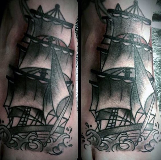 Black and gray tattoo of a sailing ship with billowing sails and waves