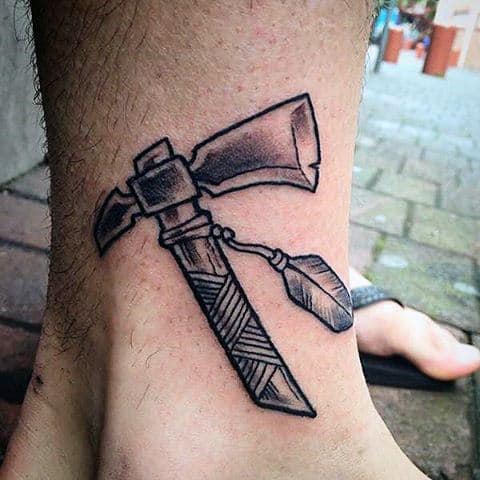 Man With Lower Leg Ankle Tomahawk Tattoo With Shaded Black Ink