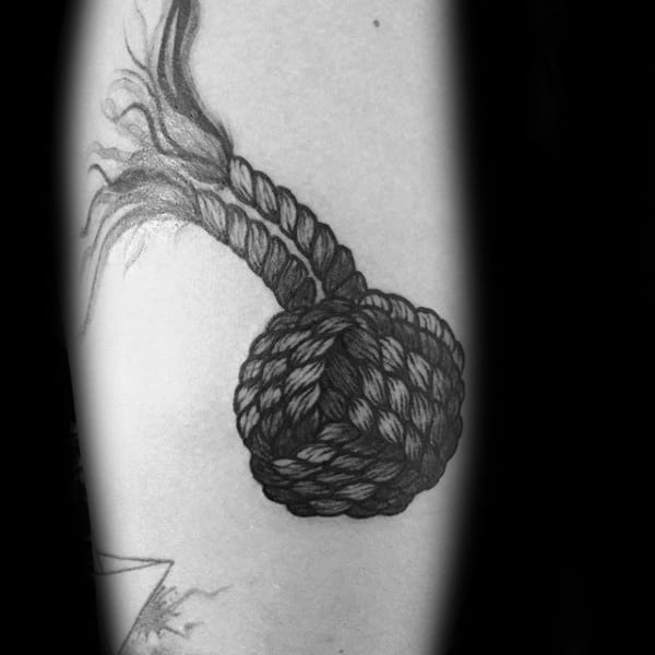 Man With Monkey Ball Knot Tattoo On Inner Forearm