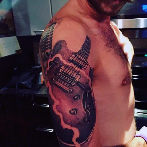 Man With Musical Instrument Tattoo On Arms