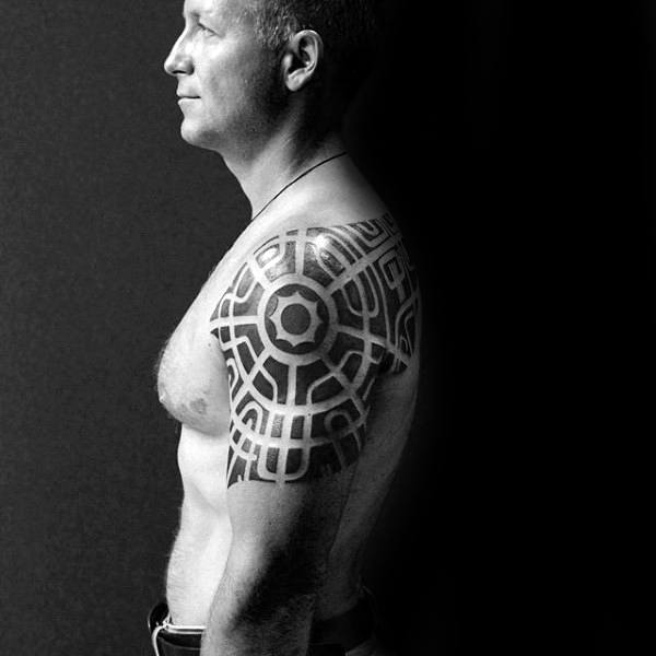 Man With Negative Space Pattern Tribal Arm And Shoulder Tattoo