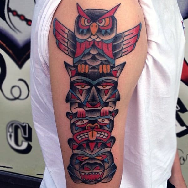 Man With Neo Traditional Style Totem Pole With Owl And Bear On Upper Arm Tattoo