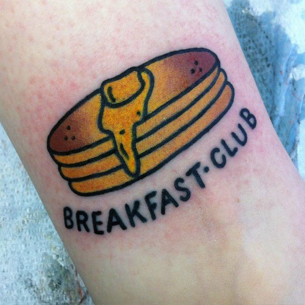 Simple pancake tattoo with syrup and butter, featuring bold black outlines and the phrase "BREAKFAST CLUB" for a fun, nostalgic design.