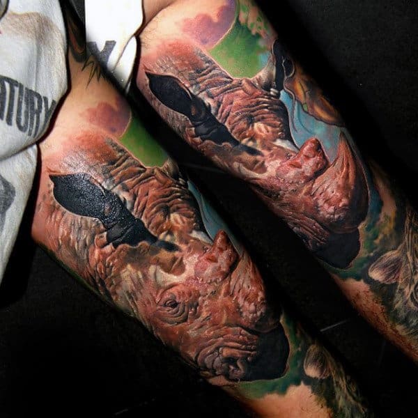 Man With Rhino Tattoos On Back Of Both Legs