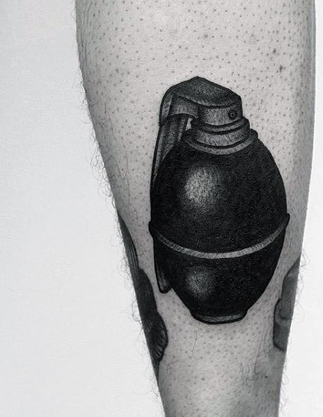 Man With Round Grenade On Back Of Leg Tattoo