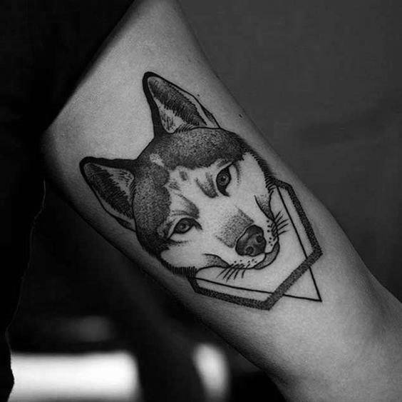 Minimalist Siberian Husky tattoo on a man's forearm, featuring fine lines, dot work shading, and a geometric frame for a sleek modern look.