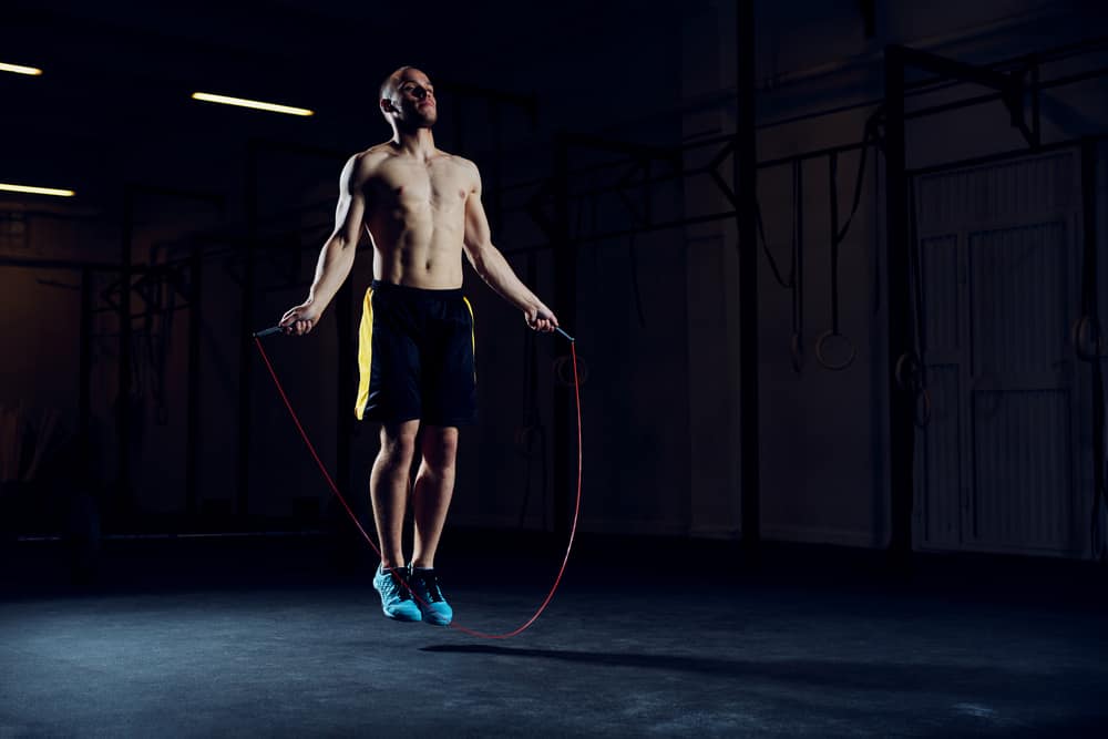 athletic young man training with skipping rope