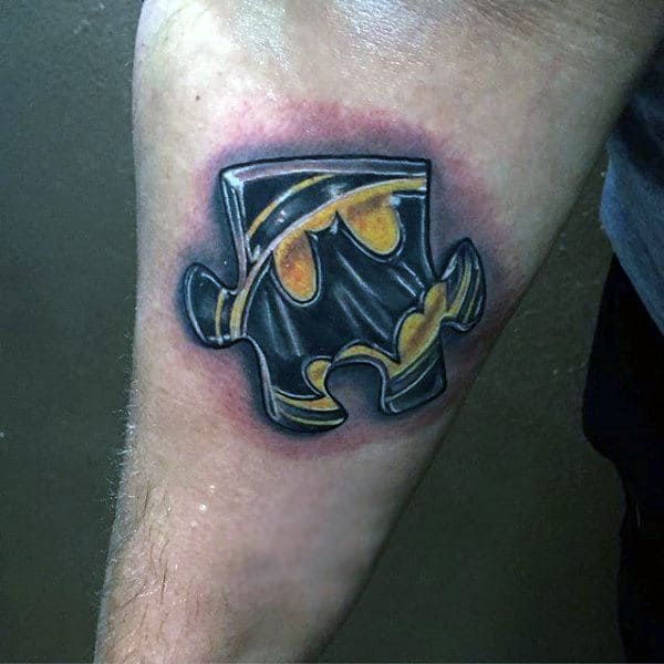 Man With Small 3d Puzzle Batman Symbol Tattoo On Arm