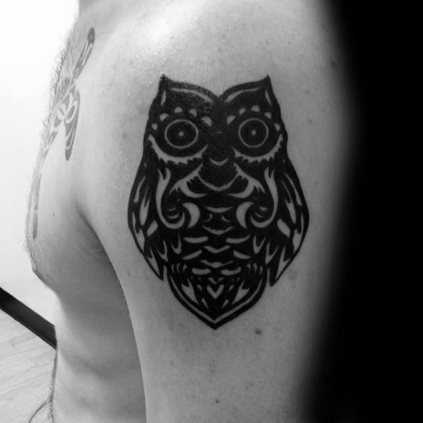 Man With Small Dark Black Ink Tribal Owl Upper Arm Tattoo