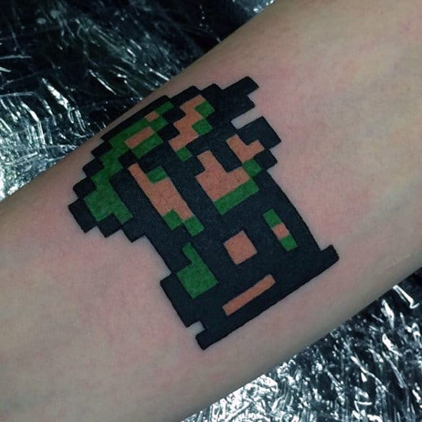 Man With Small Pixalated Zelda Tattoo Design On Arm
