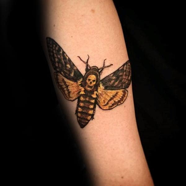 Man With Tattoo Of Black And Yellow Moth On Forearm