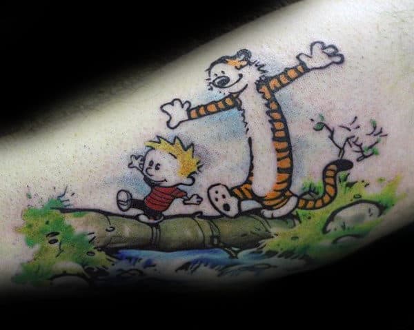 Man With Tattoo Of Calvin And Hobbes Walking Across River On Tree Tattoo