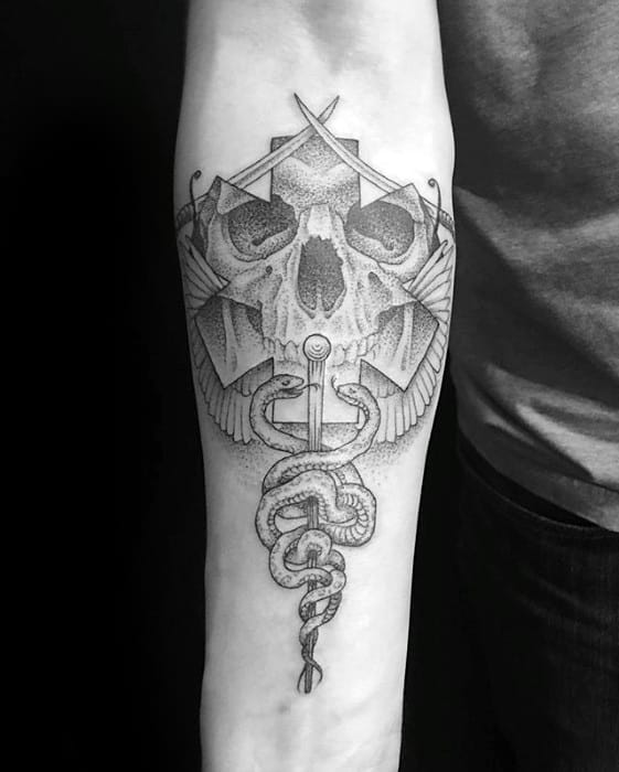 Man With Tattoo Of Star Of Life Skull On Inner Forearm
