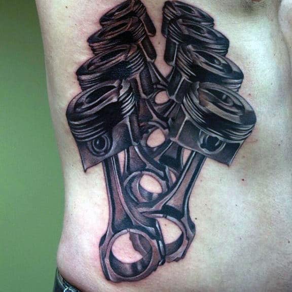 Man With Tattoos Of Trunk Head Style Piston On Ribs