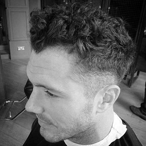Man With Thick Curly Hair And Low Taper Fade On Sides