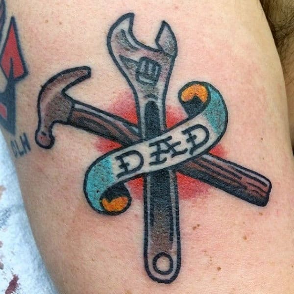 Man With Tools And Dad Tattoo On Forearm