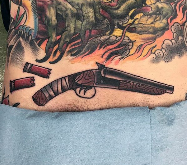 Man With Unloaded Pistol And Bullets Tattoo On Belly