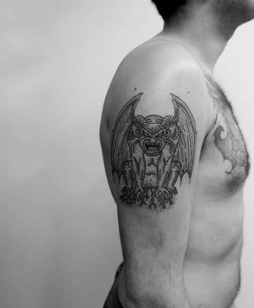 Man With Upper Arm Tattoo Of Gargoyle Design