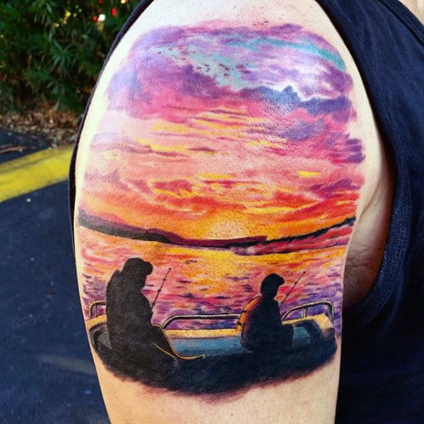 Man With Upper Arm Tattoo Of Lake Fishing At Sunset