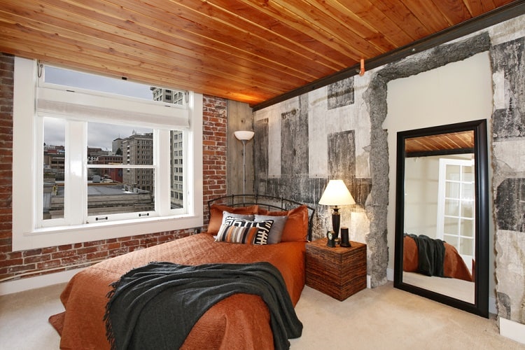 Bedroom with brick walls and a brown wooden ceiling