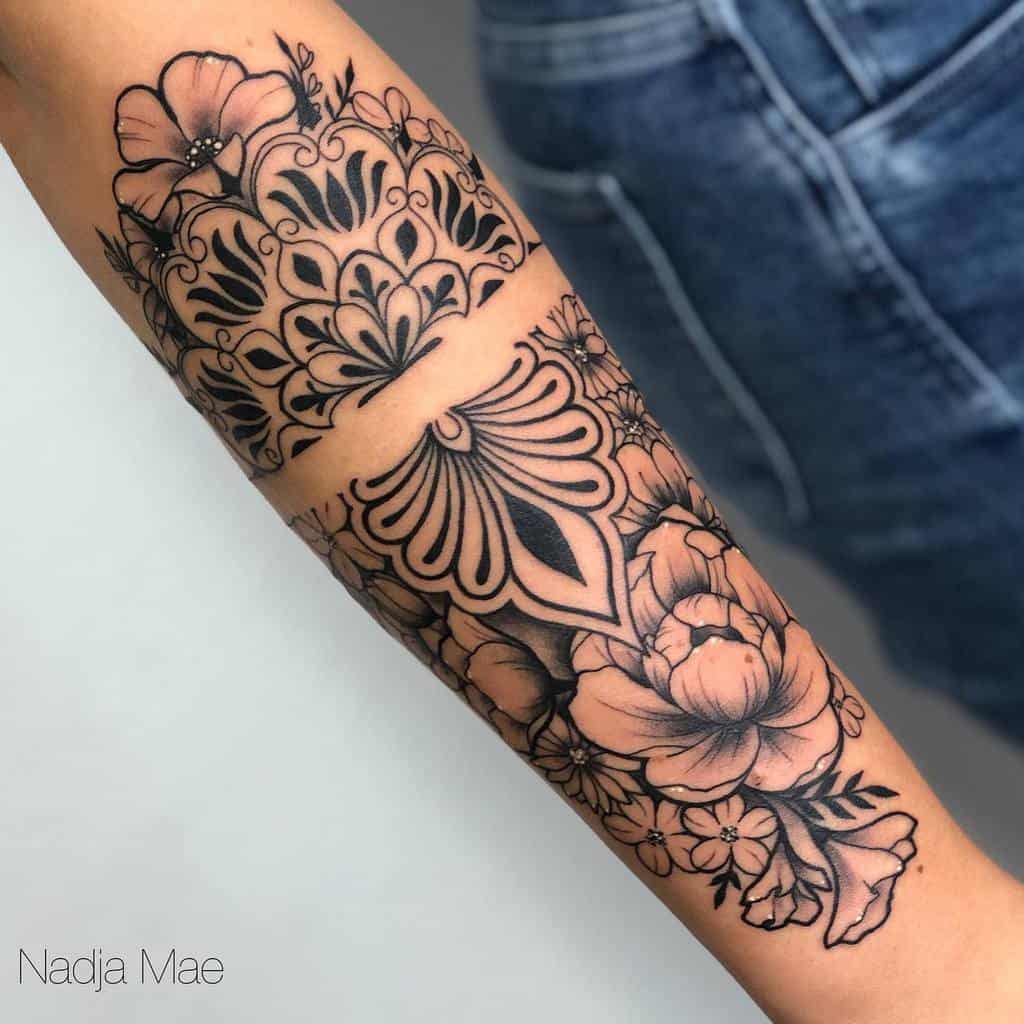 Forearm mandala tattoo with intricate floral and geometric patterns in black ink