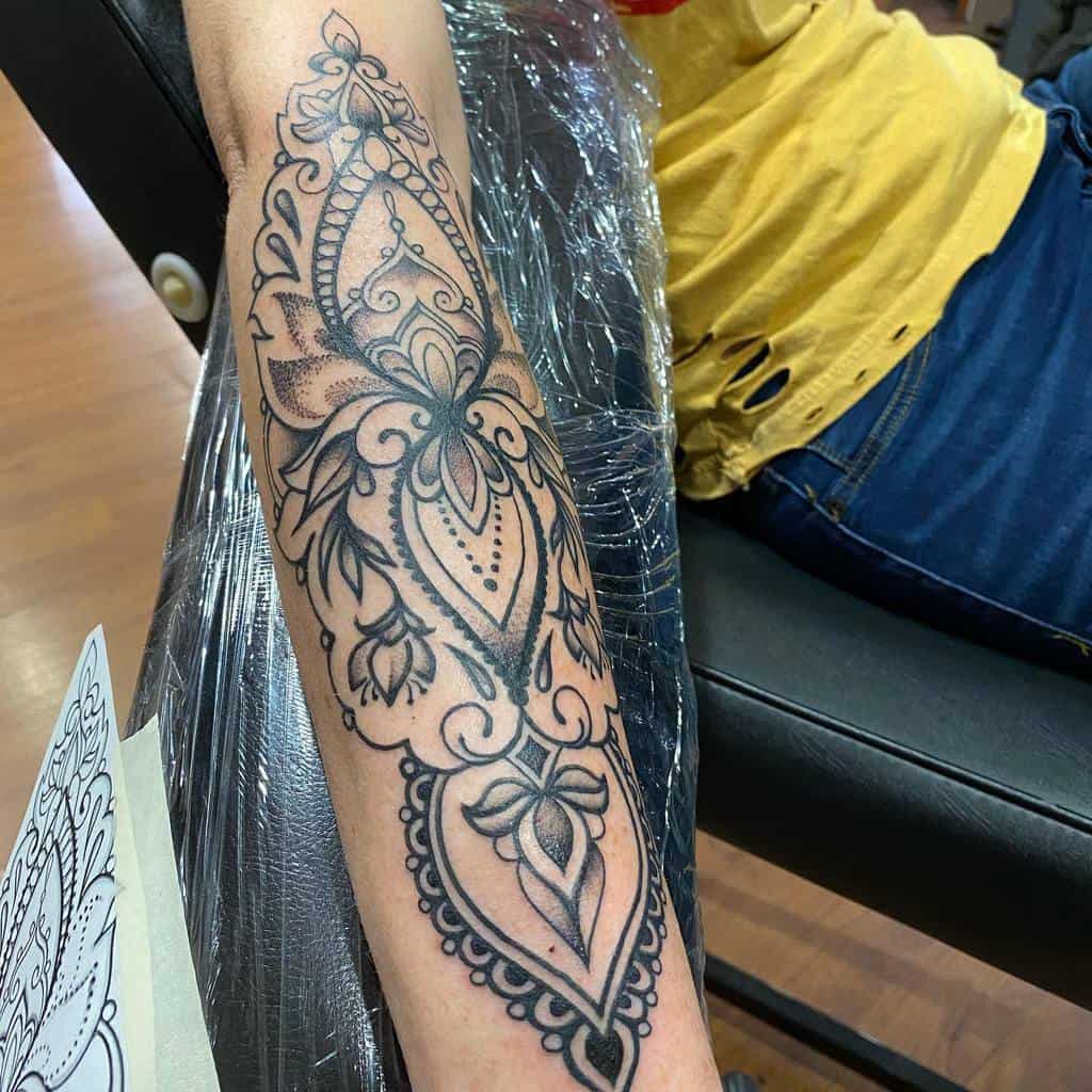 An intricate mandala tattoo design on a woman's forearm 