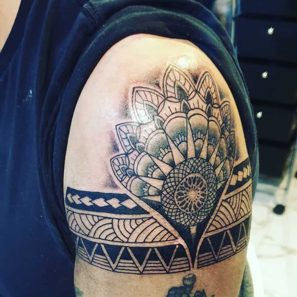 Ornate black and gray mandala tattoo on an upper arm